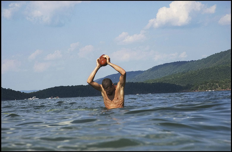 Man playing football in Raystown Lake, Huntingdon County, Pennsylvania. Linda Johnson Photography, Linda Johnson Photographs.